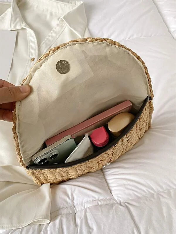 Our Amalfi clutch bag is open on a bed, showing it's large size and what you can fit inside. The perfect bag for a holiday.