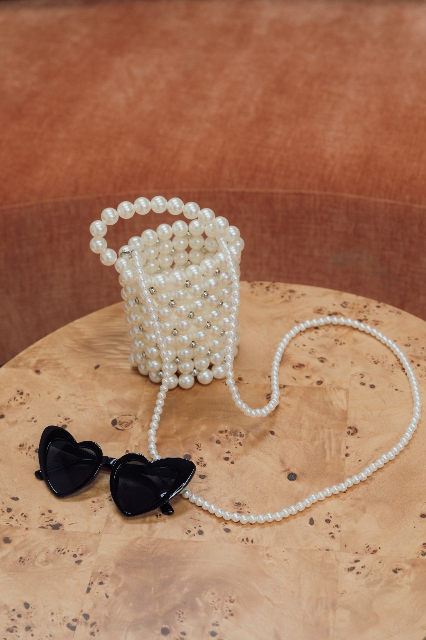 Our Bella bag with black heart sunglasses, crafted entirely of pearls, with a touch of diamante sparkle scattered between the pearls. Shown free-standing here with the two handle options, over the shoulder and a shorter hand-held length. Perfect for all hen parties and brides to be