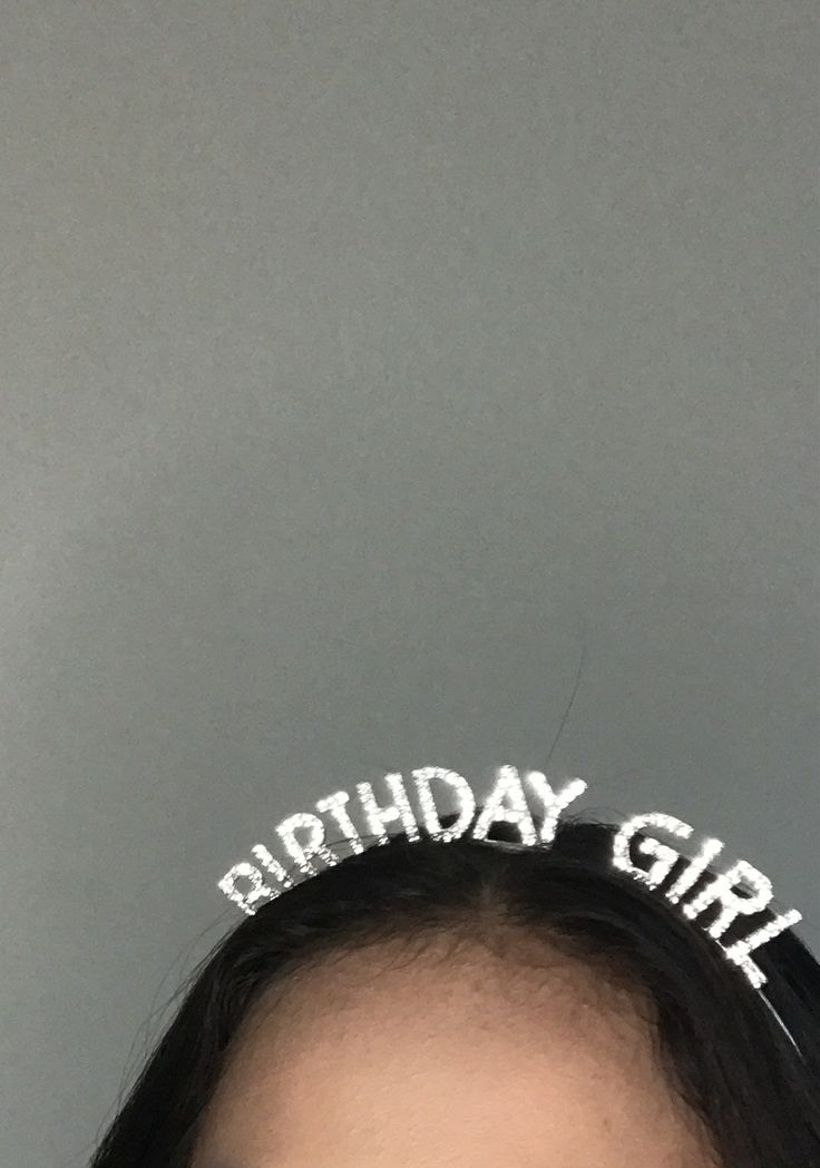 Close-up of our 'Birthday Girl' diamante headband worn on a woman's head with a grey background. Showing the sparkle that our headband can create when the light catches the diamantes. Adding a glamorous touch to any birthday celebration.