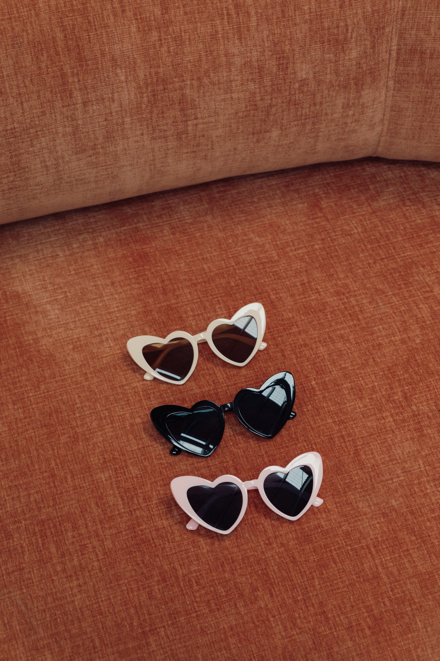 Our Black Heart Sunglasses showing our 3 colour variations, White, Black and Pink in a row from top to bottom. Perfect for hen party occasions or festivals