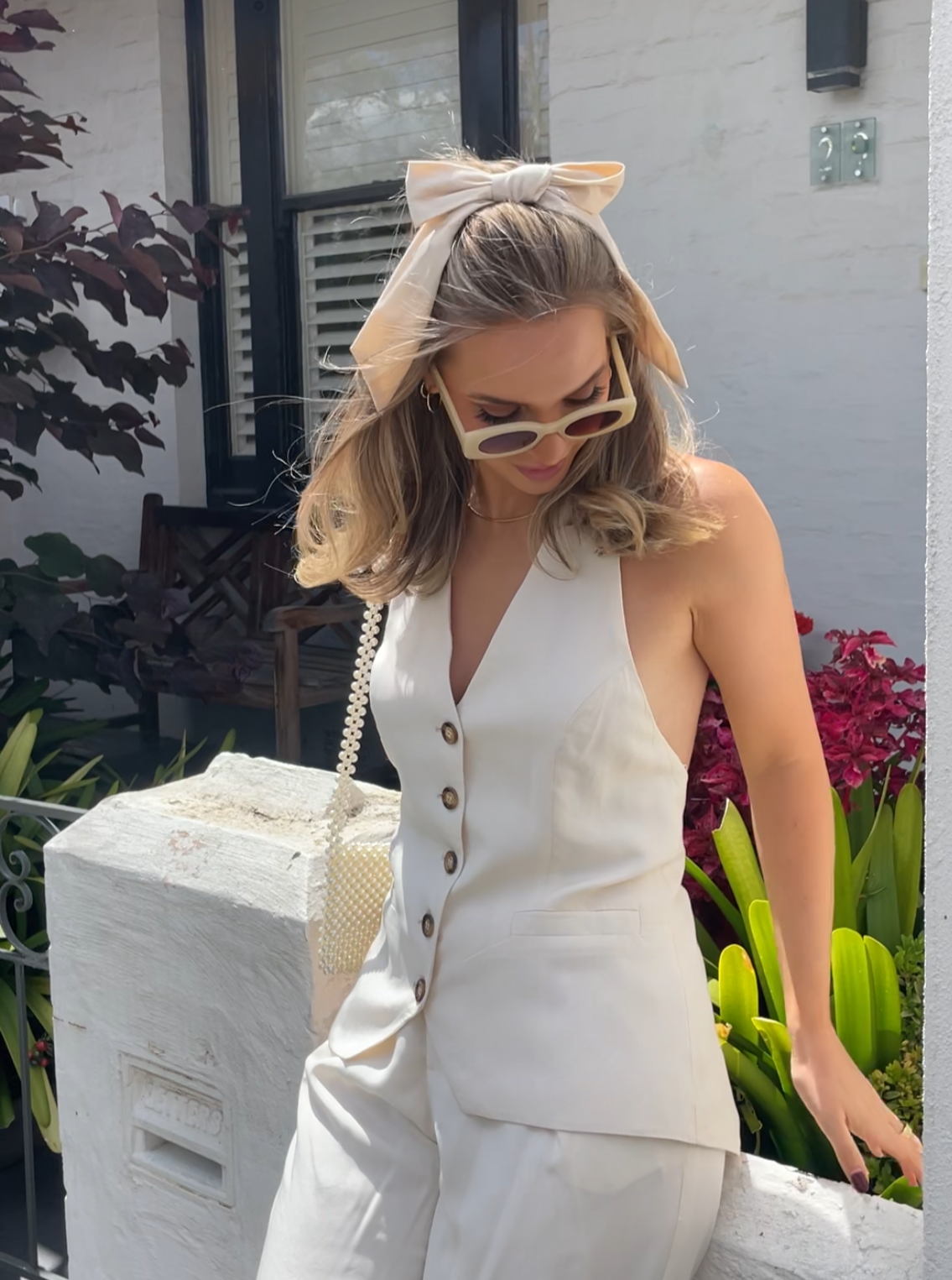 Kelly wearing our Blossom Bow Hair Clip, in a half-up half-down style. Kelly's blonde hair and white outfit really compliments the soft creamy latte colour bow that's in a satin/silk material, giving a delicate and cute addition to your outfit for any event or brides to be