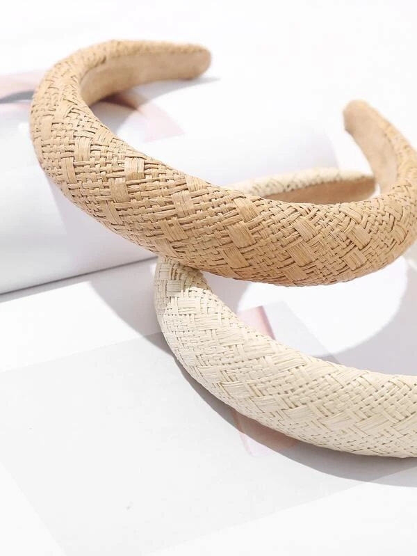 Close up of our two colour options of our capri raffa straw headbands. Beige straw brown at the top and cream at the bottom. Highlighting the size variation of the straw weaves within the design across the padded band. Adding a soft natural touch to your outfit day or night