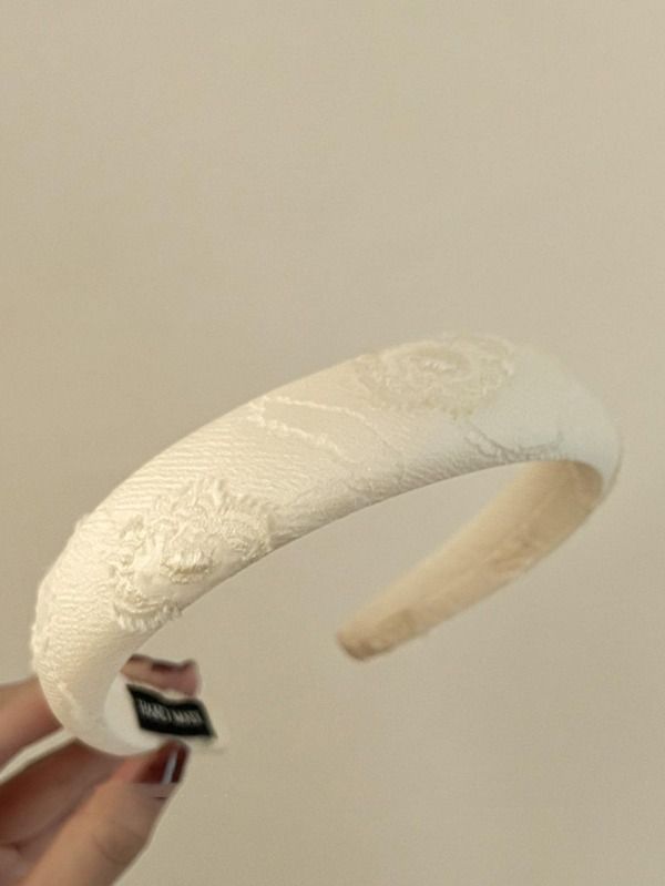 A close up of our Tulip
Ivory Headband, with Jacquard fabric and delicate floral design. Adding softness to any bridal look or day event