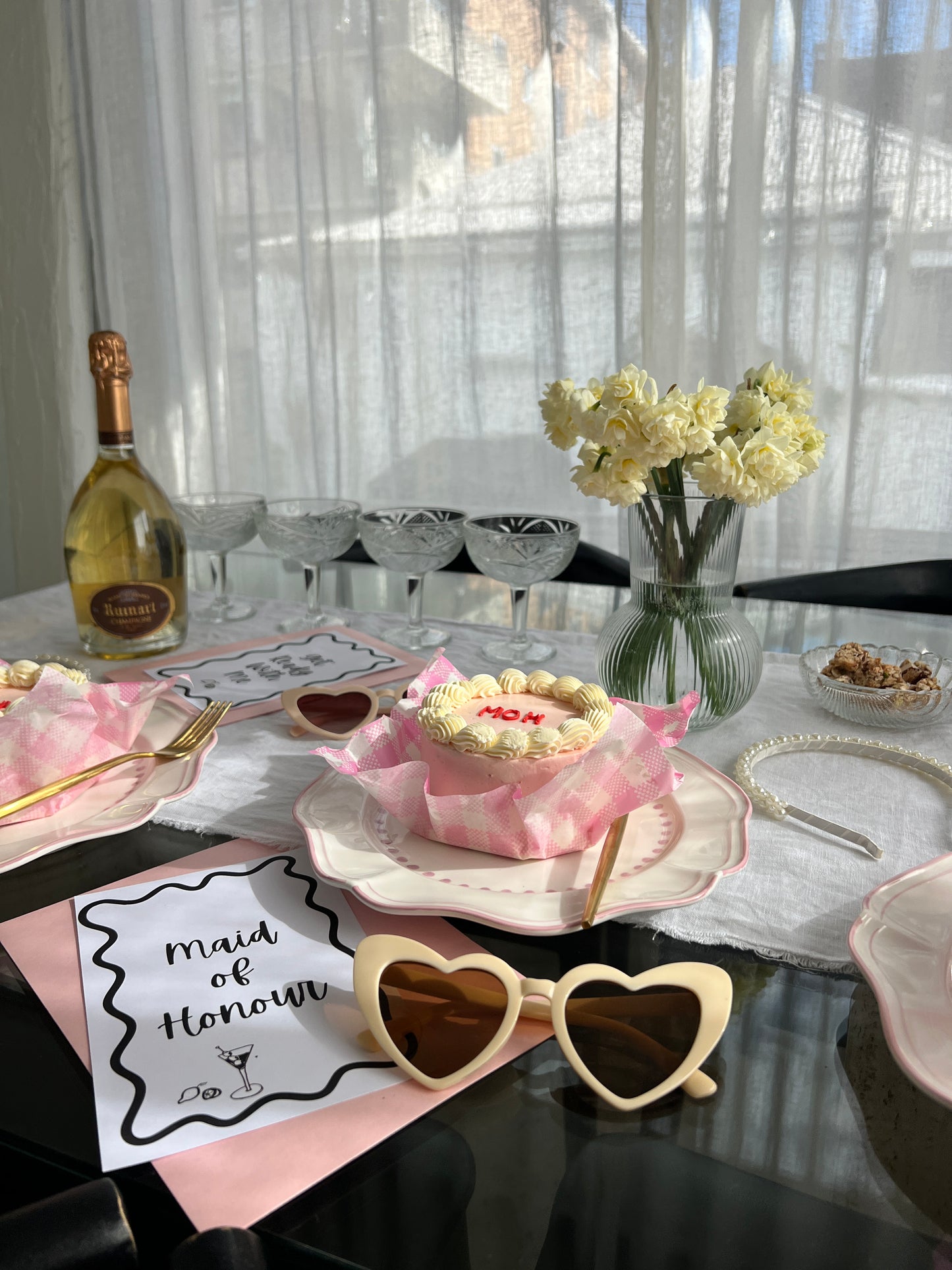 Our Cream heart shaped sunglasses, shown in a bridal set up with a table, cake, bubbles and a maid of honour place setting. Inspiration for when you would wear these fun sunglasses. Perfect for brides or bridesmaids