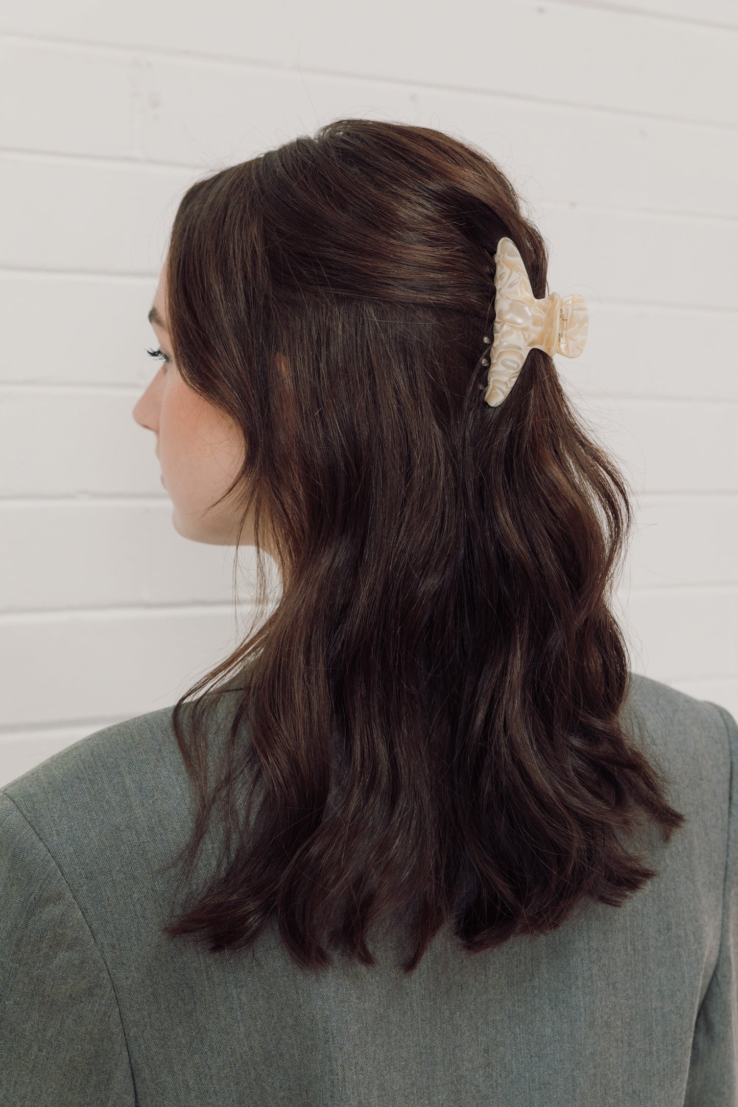 A brunette woman wearing our Flora hair clip in a half up half down style. Showing the sheen of the buttery colour and marbled acrylic design. Versatile for any occasion