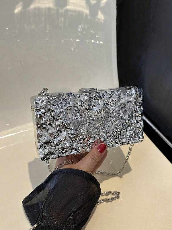 Another angle of our Lexi Chrome acrylic bag, highlighting the different levels of the textured mirror design and how the light catches it. Shown here with the silver chain shoulder attachment, adding a practical and fun clutch bag for your next event.