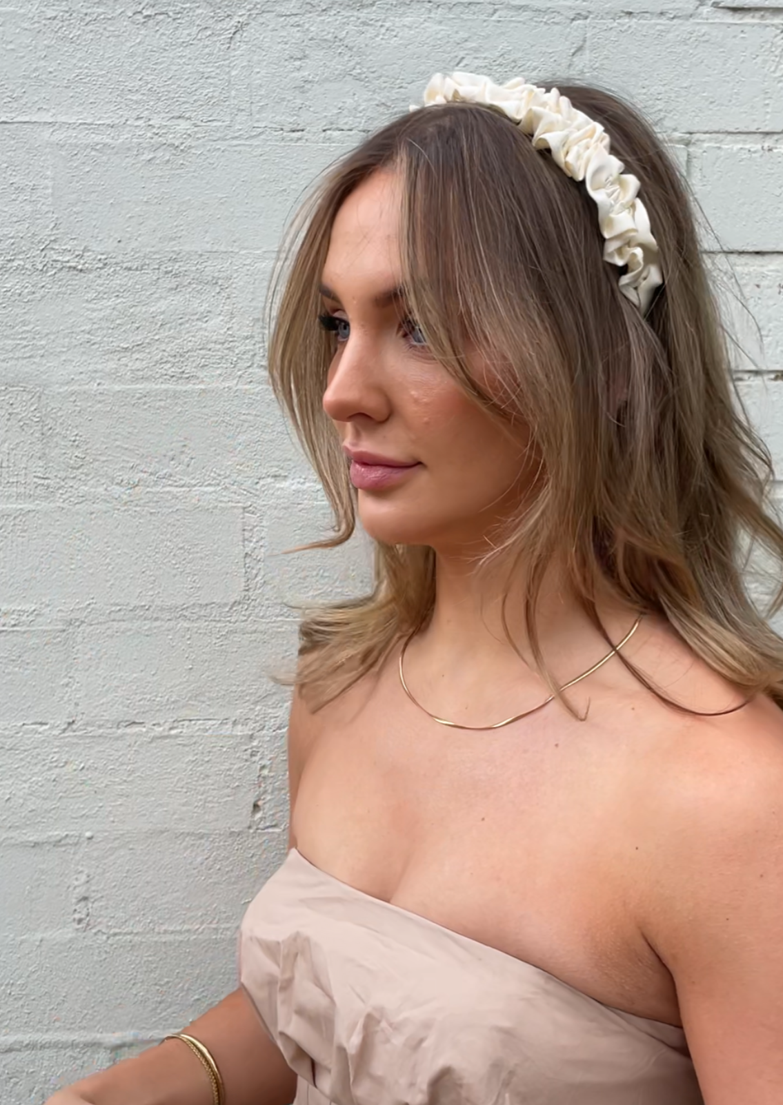 Our Lily headband being worn, showing the soft cream ruffled design of the satin/silk material. Perfect for any bridal party or bride on the wedding day.