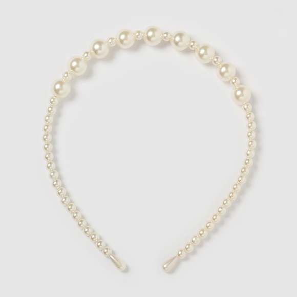Our Remy headband against a white background, highlighting the pearl colour and shine. A timeless addition to any outfit for your next formal event or bride to be