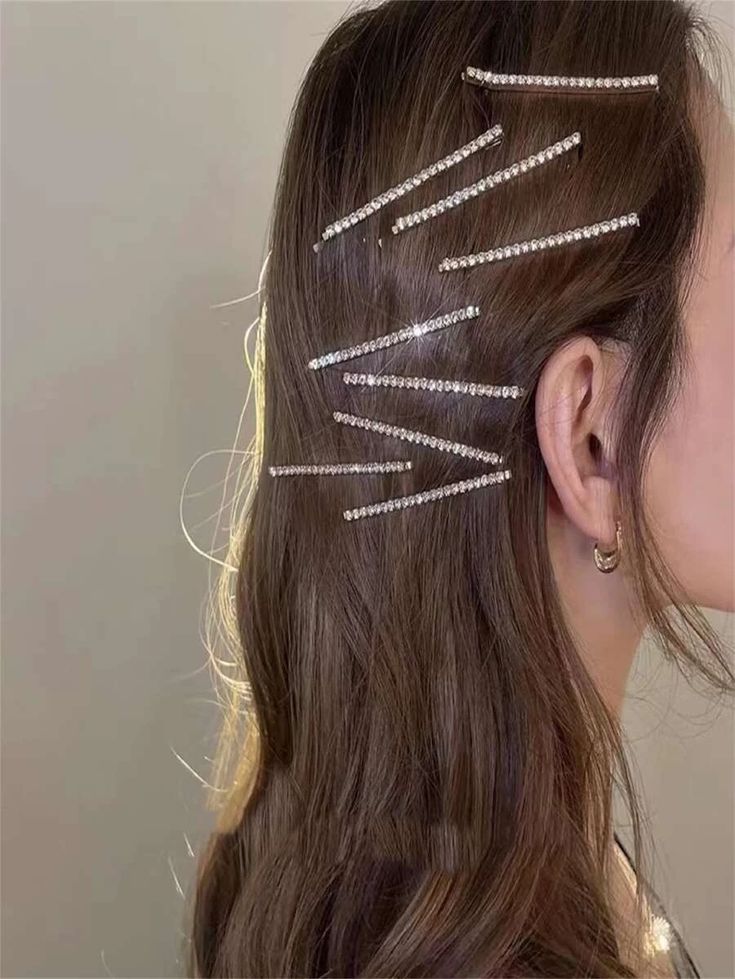 A brunette woman wearing 9 of our Rhode diamante hair clips, showing their small size and continuous strip of rhinestone design for added sparkle. Perfect for bride or bridesmaid hair accessories