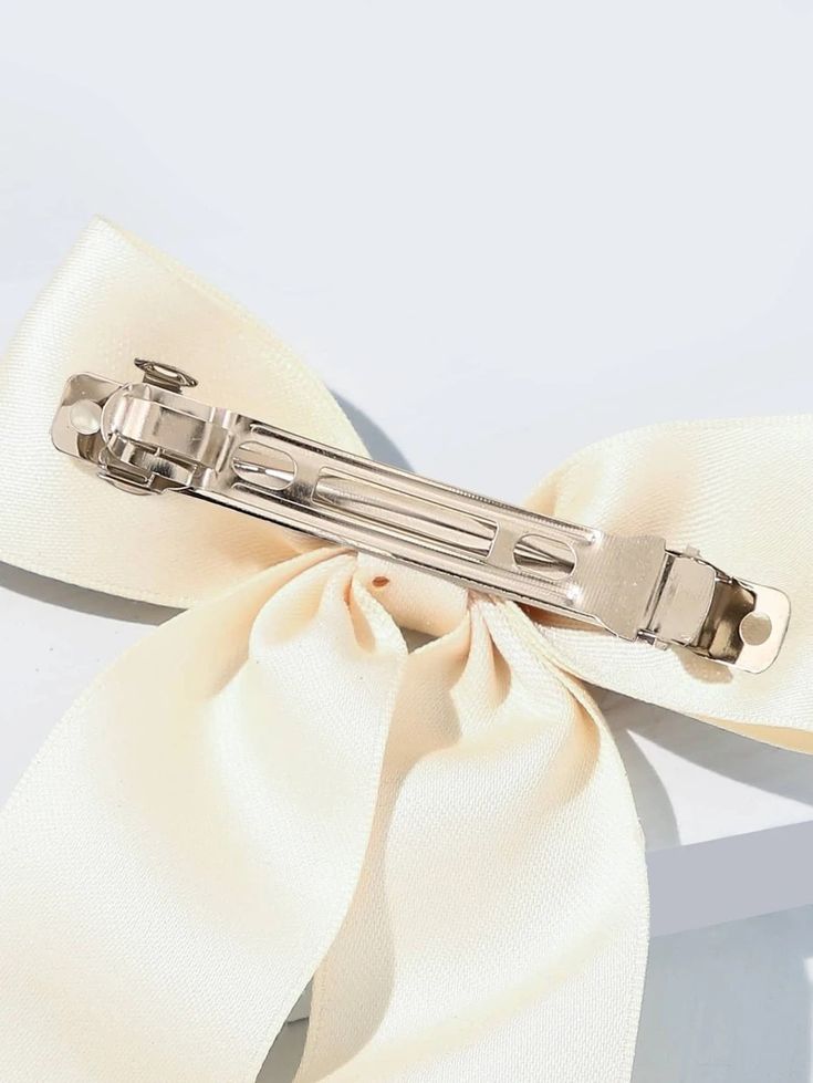 A close up of our Rose Bow Hair Clip, showing the sliver clasp and how the bow clips into the hair securely and is hidden. Adding softness to your next outfit for your next event