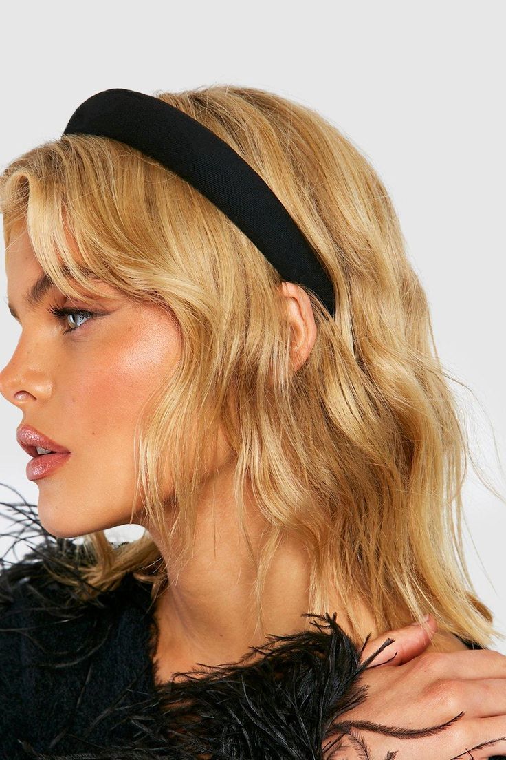 A blonde woman wearing our storm black padded headband. Highlighting the dark colour and height of the band whilst wearing. Perfect for bridal events or formal events.