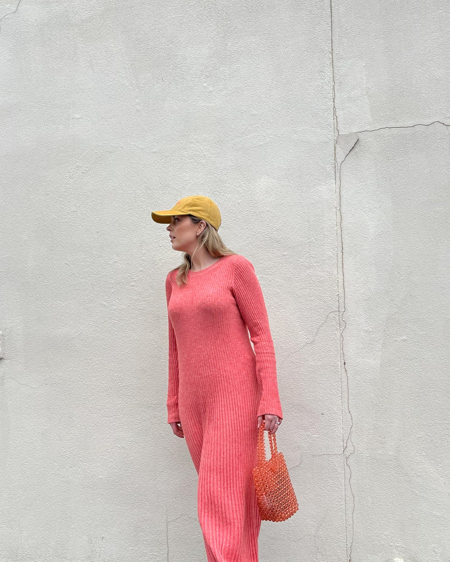Coral wearing our Sunset Sorbet deep yellow faded denim cap. Shown with a side profile and coral coloured dress for colour comparison. Perfect for all day activities and comfort