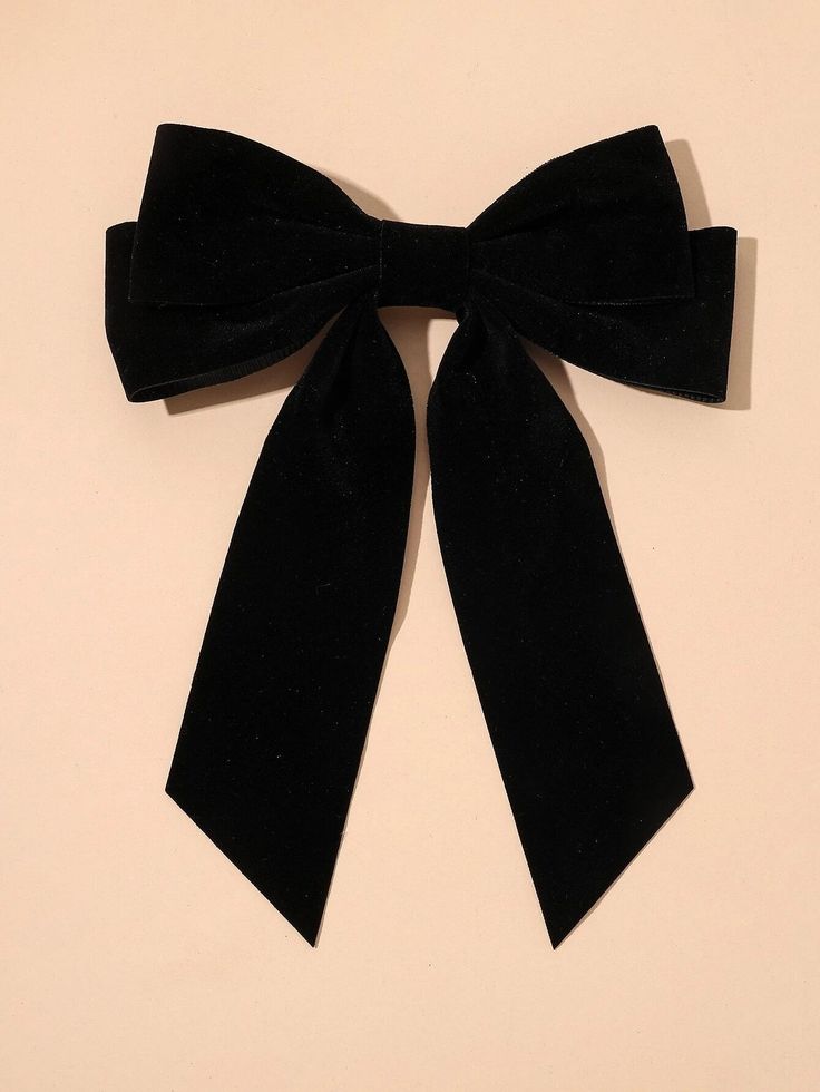 Our Viola Bow hair clip, with black velvet fabric and double bow detail. The silver clip is hidden by the bow and creates a secure look. Highlighting the longer length bow style. A chic addition to any formal event or wedding guest