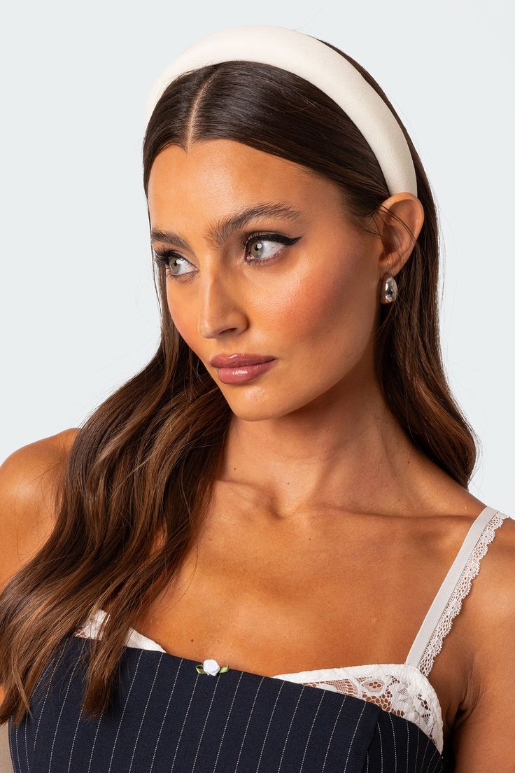 A woman wearing our Creme headband looking away from the camera. Highlighting the padded band and sheen of the satin/silk material. Perfect for a bride or bridesmaid at a hen event or wedding day