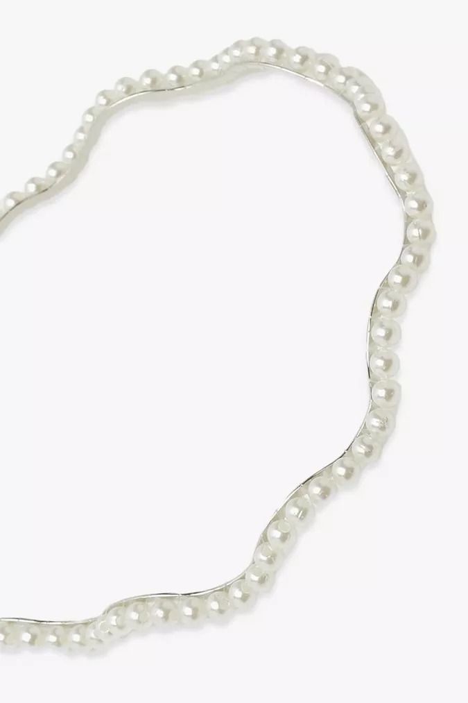 A close up of our wavy pearl headband against a white background. Highlighting the continuous Ivory pearl design and colour, adding a delicate touch of elegance to any bride or bridesmaid event.