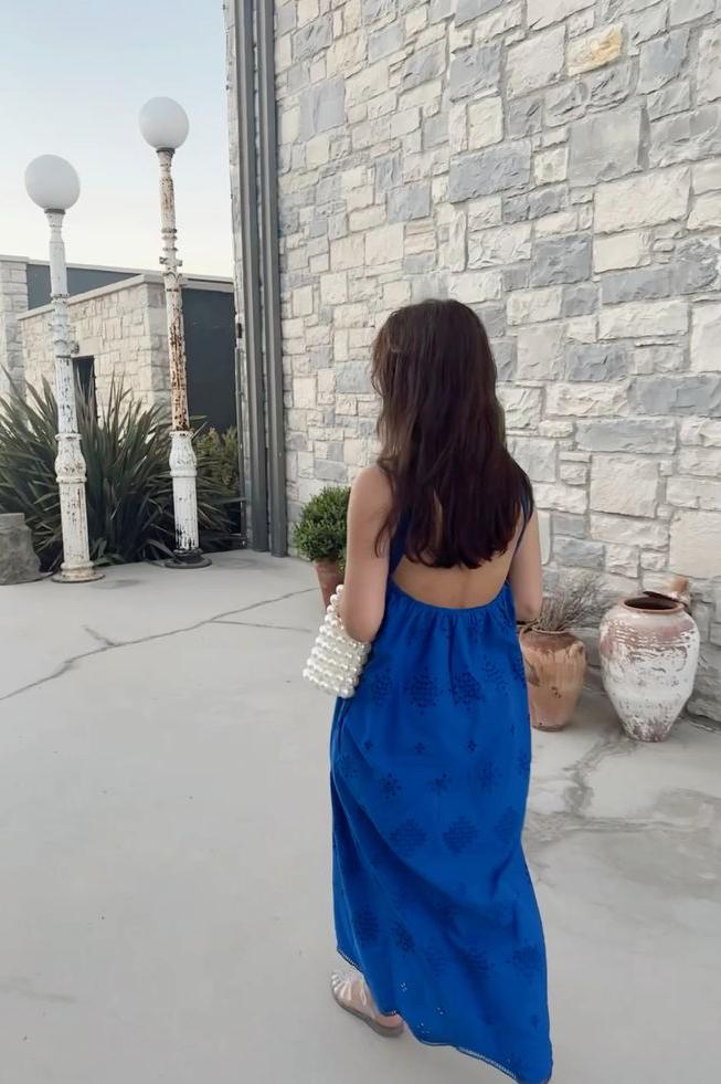 Our Bella bag being carried by a girl in a bright blue outfit. She is holding it over her arm, using the shorted length handle. The perfect evening bag for all your essentials even on holiday.