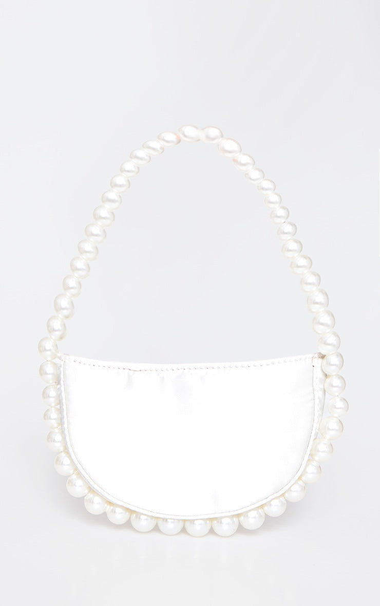 Oour white leather Azalea bag sat hanging to show its size. Showing the pearl beaded handle that continues around the bottom of the bag. A luxury addition to any outfit or bride to be