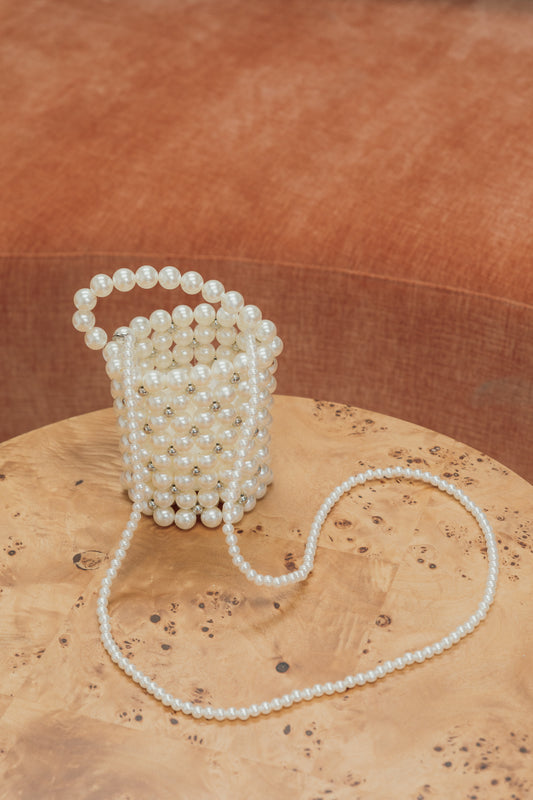 Our Bella bag, crafted entirely of pearls, with a touch of diamante sparkle scattered between the pearls. Shown free-standing here with the two handle options, over the shoulder and a shorter hand-held length. Perfect for brides or adding class to your next event outfit