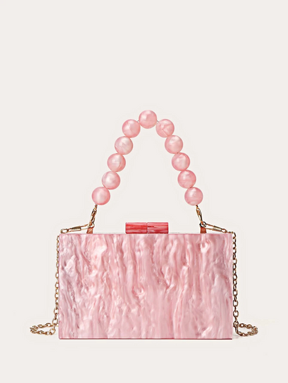 Our Candy pink marbled Acrylic bag against a white background, showing two handle options. A short beaded option and a longer thin gold chain for a over the shoulder option.  Perfect to add a pop of colour to your outfit for day/evening events