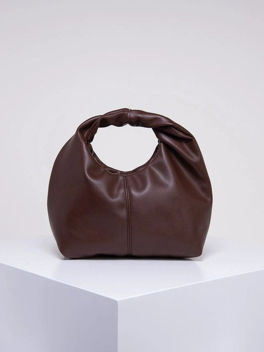 Our Chocolate PU leather bag on a white surface. Highlighting the rich colour and sheen of the material, with a seam detail around the middle of the bag. Perfect for day to do or dinner dates. Multifunctional