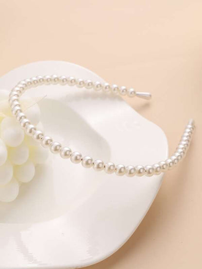 Our Daisy continuous pearl banded headband against a neutral background. Highlighting the pearl colour and sheen of the pearls. Perfect bridal wear or if you want to dd a touch of glamour to your evening outift