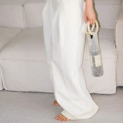 Woman holding our diamante wine bag, containing a bottle, held at her side, showing a size comparison. Adding sparkle to your next party or gift bag