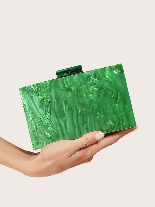 A Woman holding our Emerald green acrylic bag, showing a size comparison. Rectangular in shape and compact clutch bag, perfect to add a pop of colour to your outfit