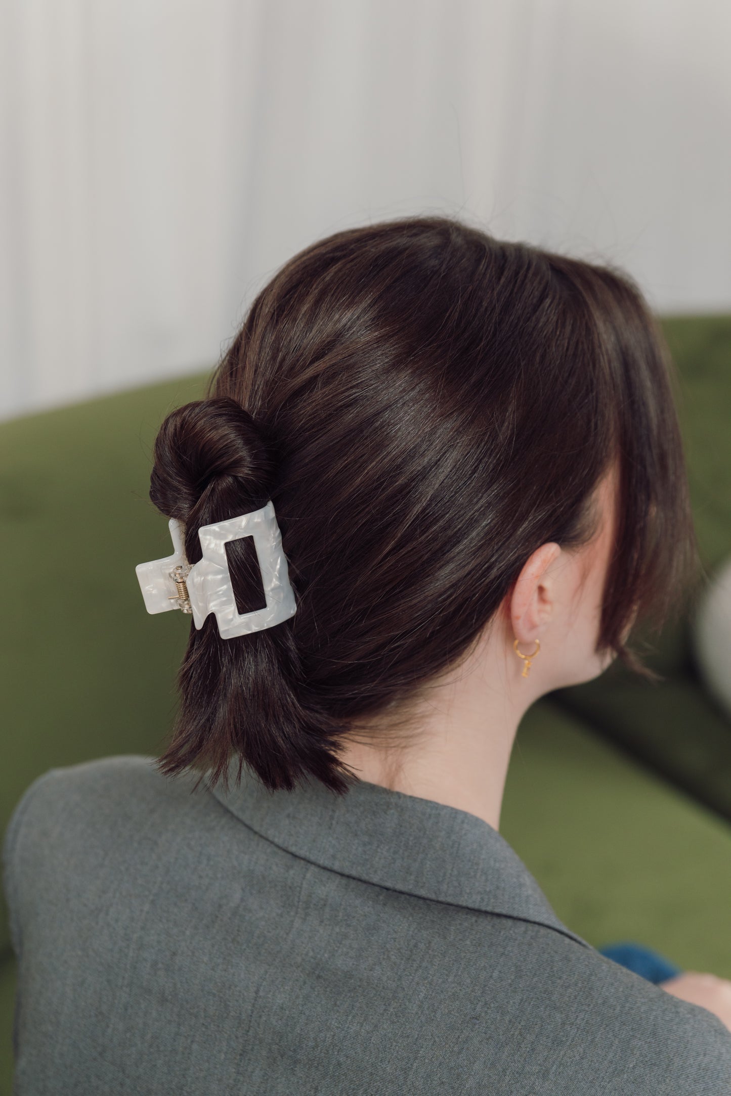 A Woman styling our Fleur hair clip holding all of her hair in a twist. Highlighting the durability of our clip and that it can hold long thick hair. Perfect for day to evening activities and events