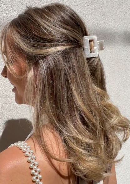 Our Fleur acrylic claw clip with ivory marble detailing. Shown styled in a woman's hair in a half up half down style. Easy way to keep your hair in place for your next event