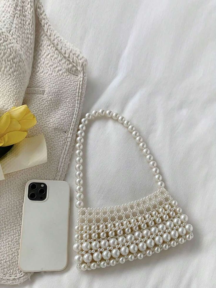 Our Gigi shoulder bag shown next to a smart phone for size comparison. This bag will fit all your essentials in for your next event. Pearl beaded bag and single handle