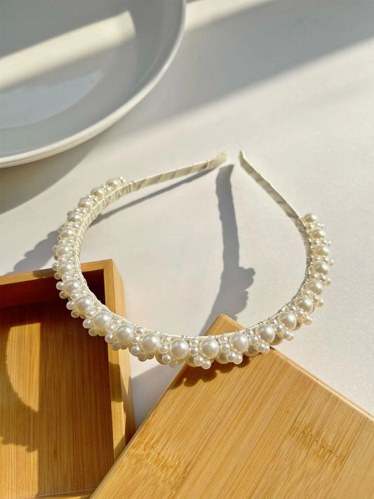 Our Iris Headband shown laying flat, with variously sized pearls clustered around the thin head band. Adds a touch of class to any outfit, brides/bridesmaids, hen parties/wedding day.