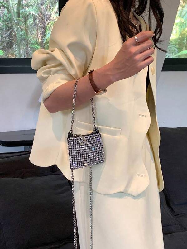 A woman wearing our Ivy Diamante bag over her forearm. Showing the two silver chain handle options that are shorter, like she's holding and longer over the shoulder option. Small diamantes across the whole bag, front and back with a silver zip opening at the top. Perfect for your next night out