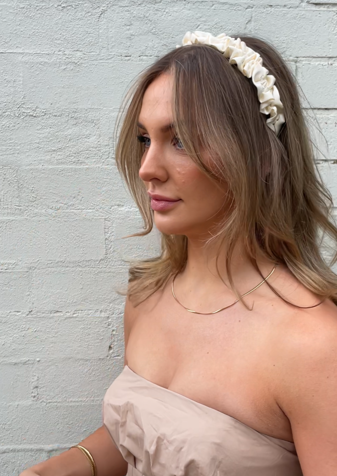 Our Lily headband being worn, showing the soft cream ruffled design of the satin/silk material. Perfect for any bridal party or bride on the wedding day. 