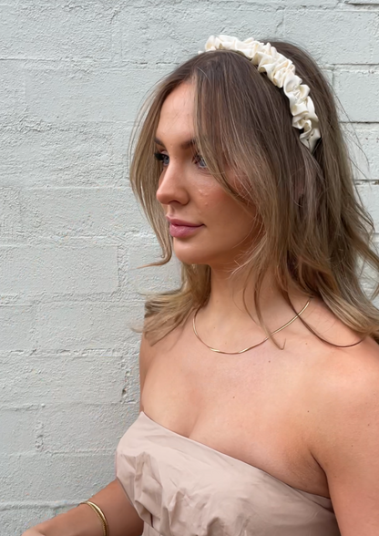 Our Lily headband being worn, showing the soft cream ruffled design of the satin/silk material. Perfect for any bridal party or bride on the wedding day. 