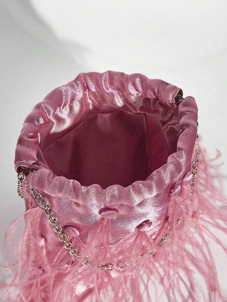 A shot of our Lulu pink velvet drawstring bag opening. Close up showing the quality of the velvet material and the soft feather detailing. Perfect to hold all your essentials for your next event.