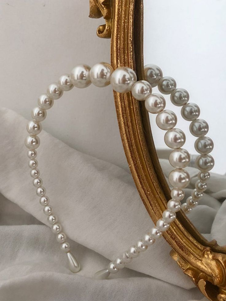 Our Orchid headband, shown balanced against a vintage mirror. Highlighting the size increase of the pearls across the band, where they are smallest at the ends and biggest at the middle. Elevating your bridal look on your wedding day or bride to be on the hen party