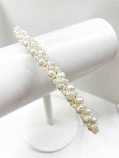 Close up and a birdseye view of our Iris Headband, with variously sized pearls clustered around the thin head band. Adds a touch of class to any outfit, brides/bridesmaids, hen parties/wedding day.