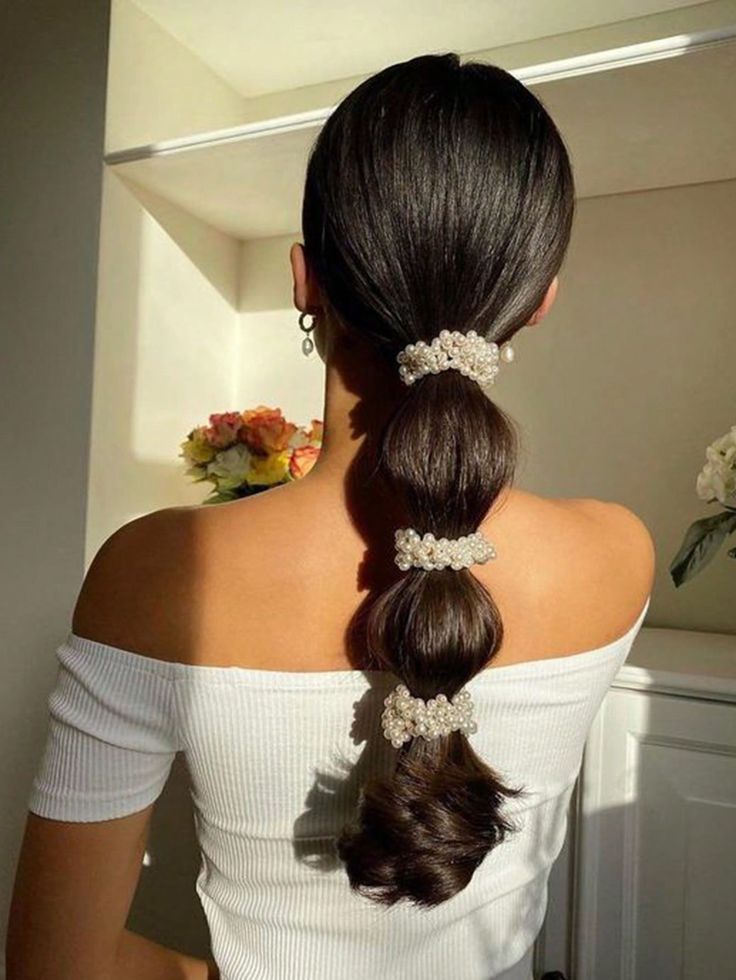 A brunette woman wear our three Pearl Hairbands in a pony-tail style. Clusters of pearls around the entire band, adding timeless charm to any occasion or must-have for brides or party-goers.